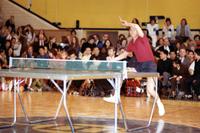 Action shot of Chinese athletes playing table tennis for a crowd of spectators